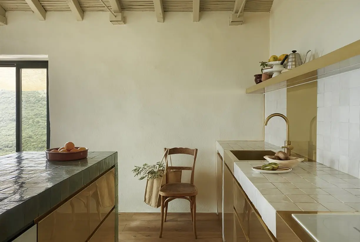 Kitchen counter with brass fronts and wooden chair, Isna, Mani