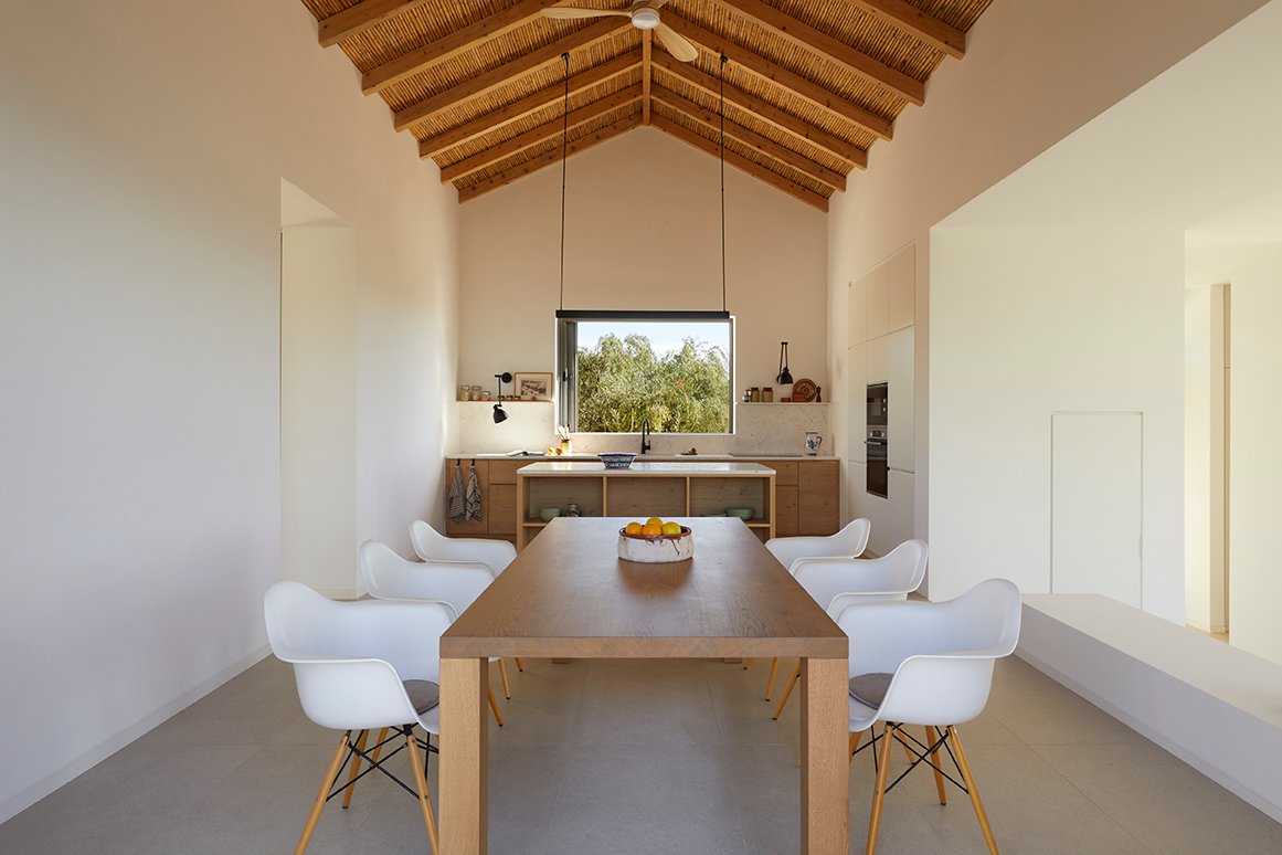Long dining table in the open-plan kitchen with timber roof, AS House, Messinia